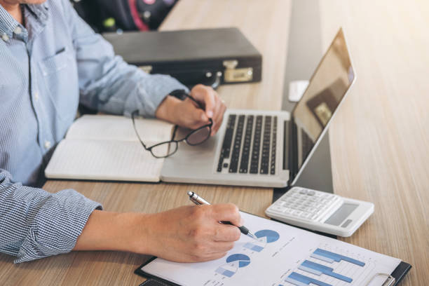 istock Professional businessman working at workplace with report, Doing finance on laptop, document graph and analysis business strategy to development profit 891126574