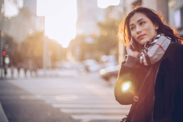 istock Young woman using mobile phone on the street 891131454
