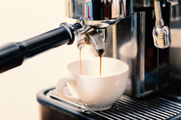 istock Coffee making, hot coffee flowing into a cup from espresso machine 891144900