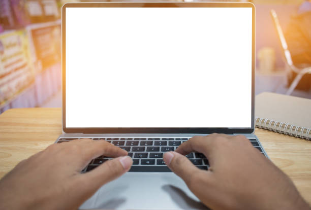 istock Male hands using modern laptop on keyboard in home office on wooden table with mock up white screen forcopy space for text. 891153204