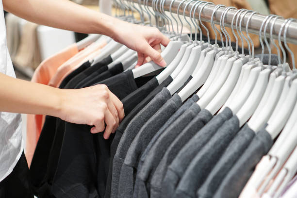 istock Hands choosing clothes on a rack in a showroom. 891158962