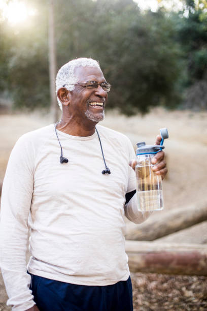 Senior African American Man Drinking Water A senior African American Man enjoying refreshing water after a workout water athlete competitive sport vertical stock pictures, royalty-free photos & images