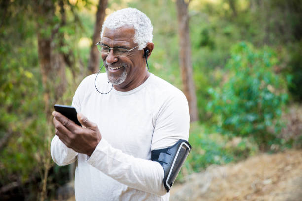 supérieur homme afro-américain vérifiant smartphone - only senior men audio photos et images de collection