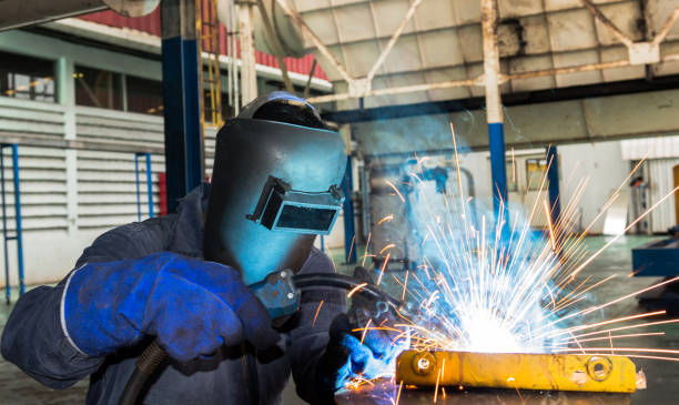 крупным планом промышленный работник сварки металла на заводе с защитной маской - protection machine grinder grinding стоковые фото и изображения