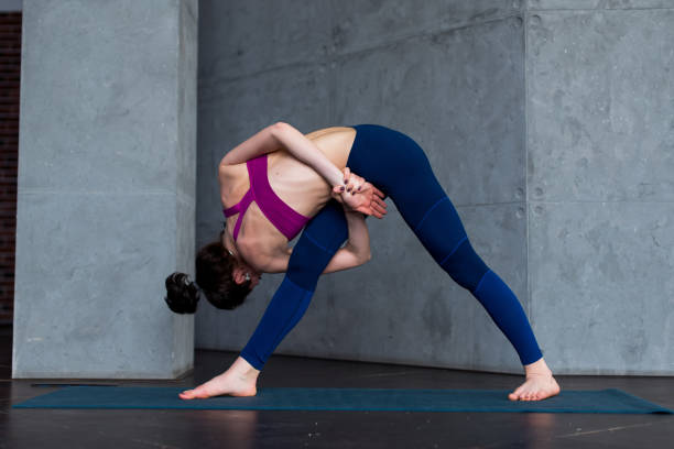 istock Sporty Caucasian woman practicing standing side angle twist position during yoga class 891189830