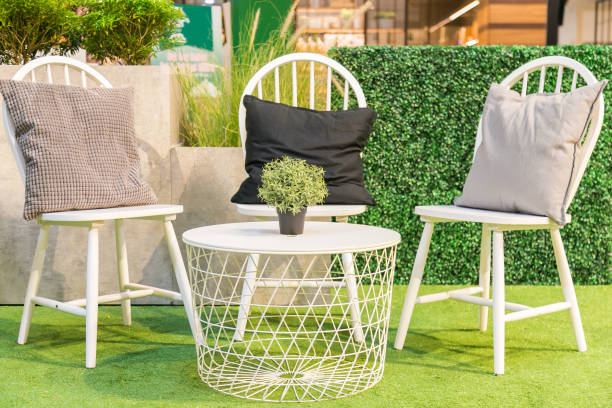 istock Pillows on a white wooden chairs and a white table on artificial grass. 891197900