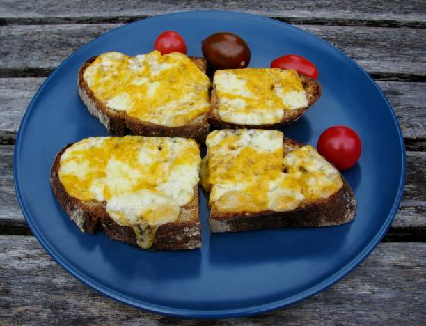 istock Melted cheese rye bread sandwiches and tomatoes on a blue plate 891217678