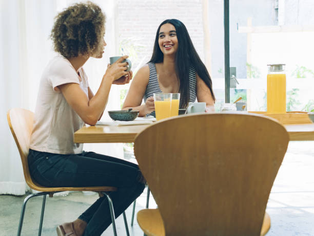 istock Happy lesbian couple talking and eating breakfast at dining table 891227122