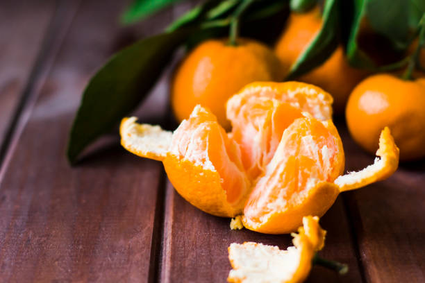 istock Fresh opened tangerine on wooden background 891264762