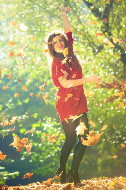 istock Playful woman outdoors playing with leaves. 891274314