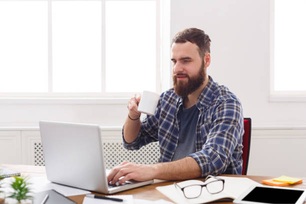 istock Satisfied businessman with laptop in modern white office 891289092