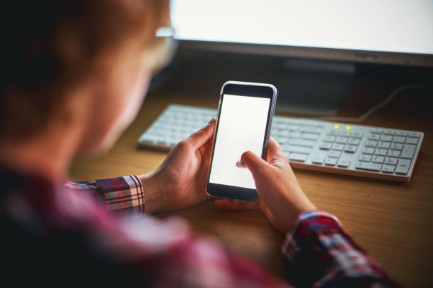 istock Woman using smartphone at desk at night 891294694