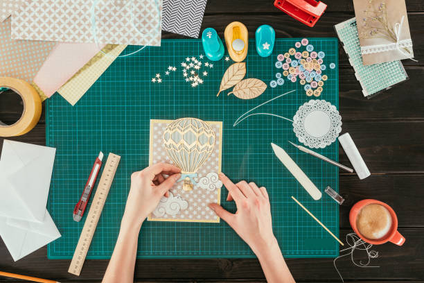 istock cropped image of woman adding decorative clouds on scrapbooking handmade postcard 891296930