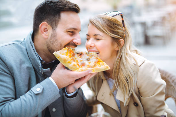 istock Love couple in a restaurant eating pizza. 891300122