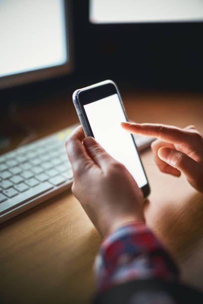 istock Nighttime shot of female hand tapping illuminated smartphone screen 891300282