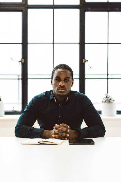istock Black Businessman Sitting in a White Office 891306452