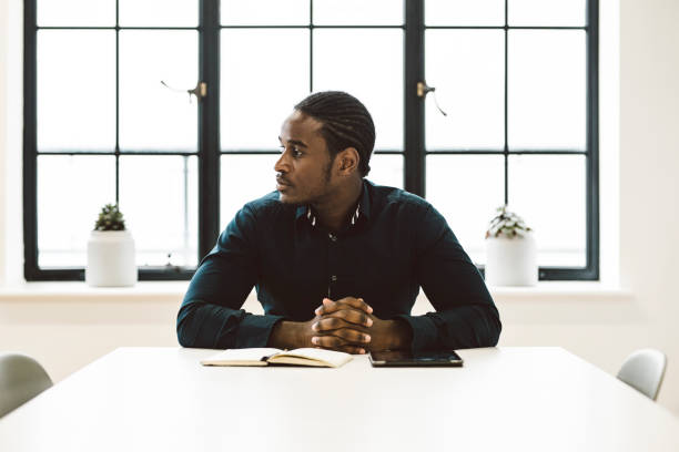 istock Black Businessman Sitting in a White Office 891306462