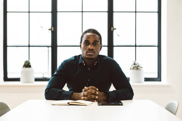 istock Black Businessman Sitting in a White Office 891306466