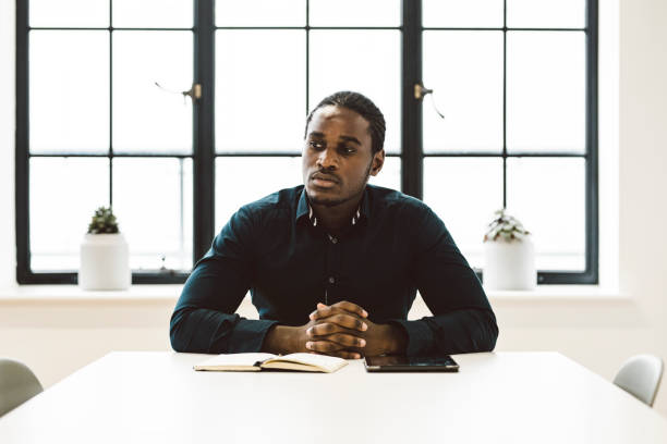 istock Black Businessman Sitting in a White Office 891306468