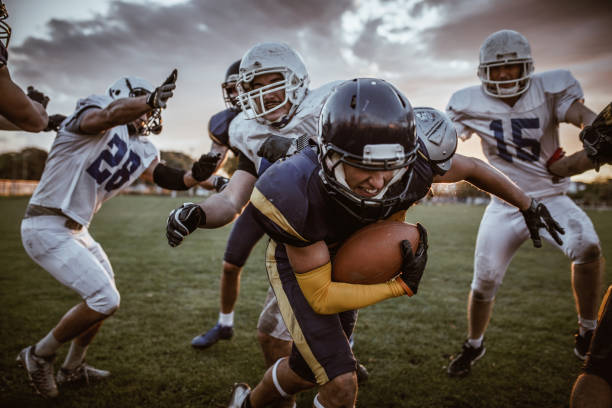 determined american football player passing defensive players on a match. - running back imagens e fotografias de stock