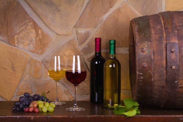 istock Red and white wine beside old cask in wine cellar 891310122
