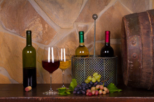 istock Red and white wine beside old cask in wine cellar 891310356