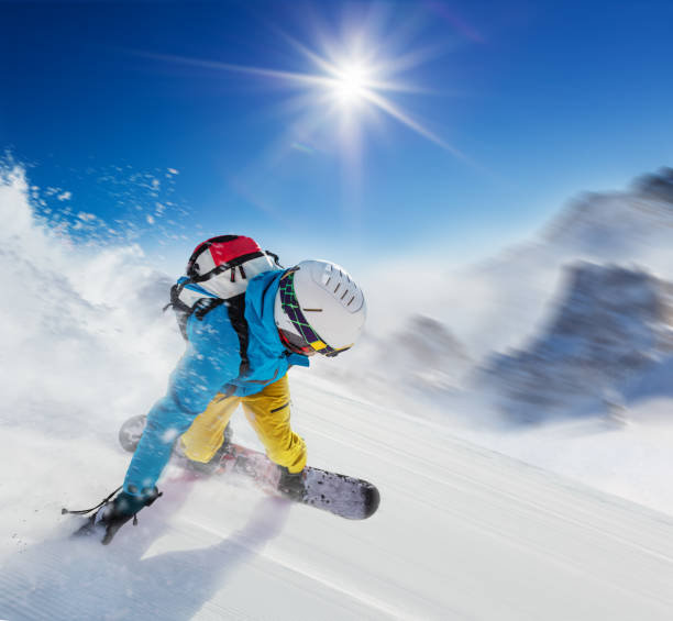 istock Young man snowboarder running downhill in fast motion 891312950