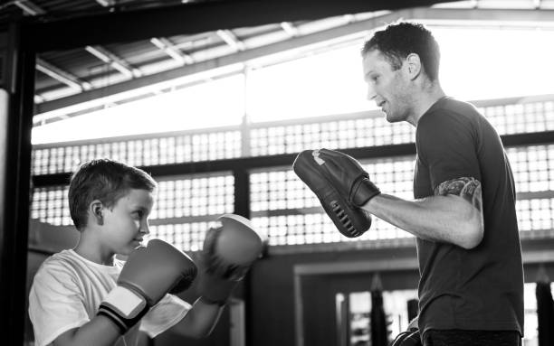 Young boy boxing with his teacher