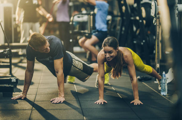 istock Young happy athletes exercising push-ups in a gym. 891318368