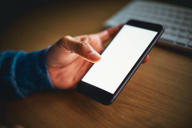 istock Male hand holding smartphone with screen lit. Nighttime shot. 891318970