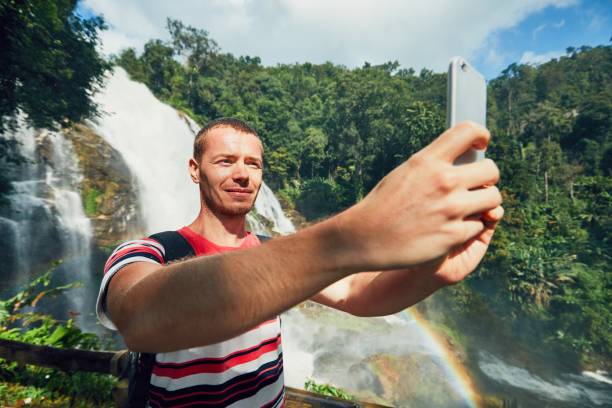 istock Tourist taking a selfie against waterfall 891319616