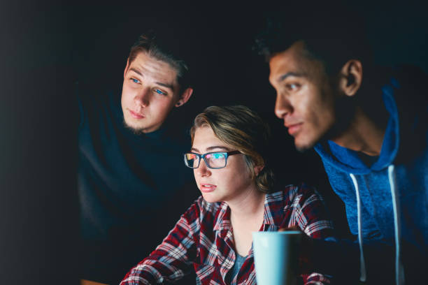 istock Three serious young people study computer monitor at night 891319704