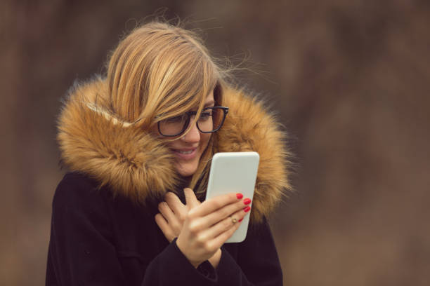 istock Beautiful woman doing a selfie on her cellphone outdoors.Winter concept. 891322536