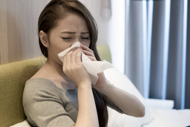 istock woman sick and sneezing 891325362