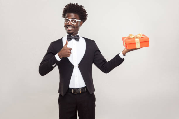 istock African man thumbs up and holding gift box. 891326552
