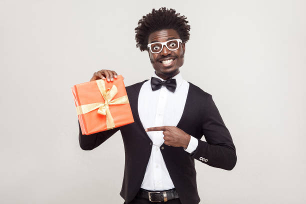 istock African businessman pointing fingers at gift box. 891326558