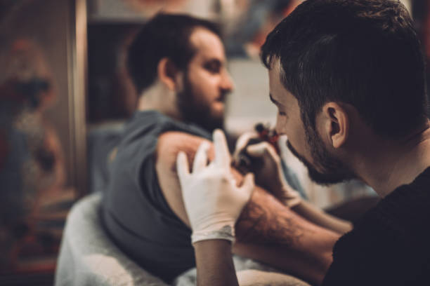 istock Artist making tattoo on man's hand in studio 891337302