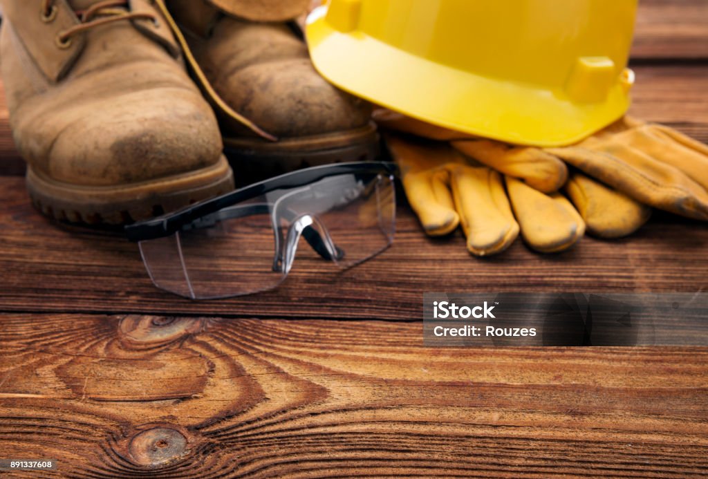 Safety first Protective wear for construction worker on wooden table Carpentry Stock Photo