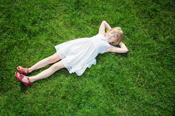 istock young girl lying on grass 891348396