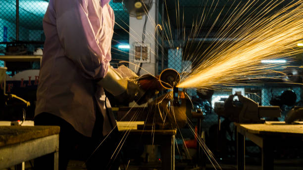 istock worker uses grinding cut metal, focus on flash light line of sharp spark,in low light 891348670