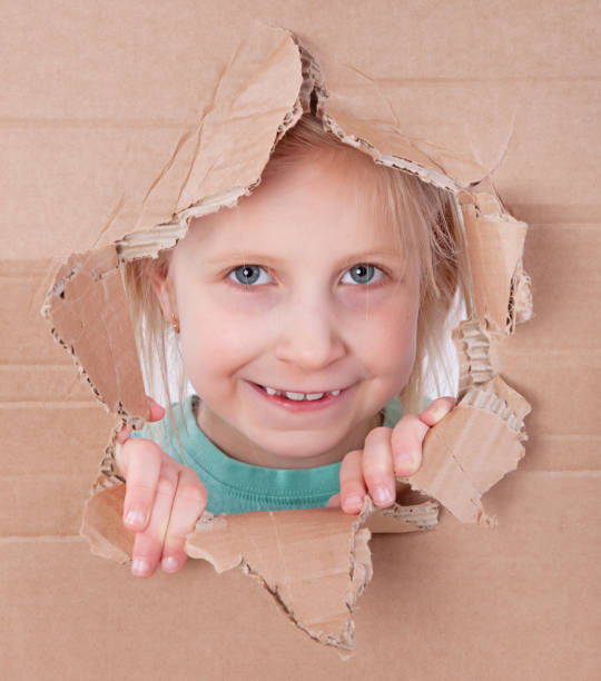 istock kid portrait in torn paper hole 891352206