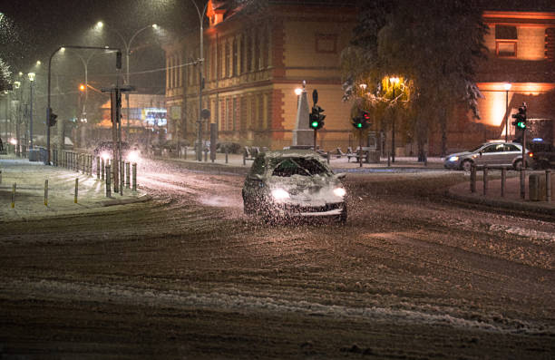 Car on the snowy road in the city