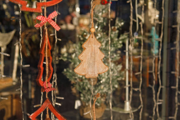 istock Toy christmas tree hanging in storefront window decorating for New Year and Christmas 891364742