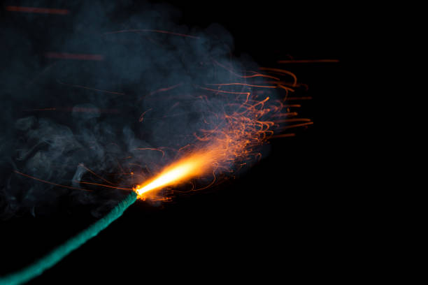 istock Burning fuse with sparks and grey smoke on black background 891365028