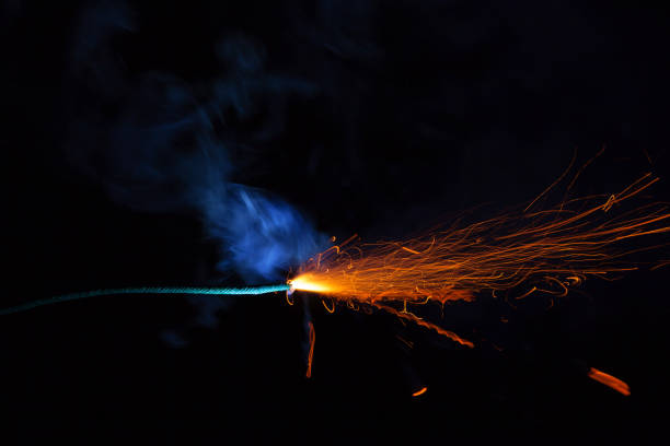 istock Burning fuse with sparks and blue smoke isolated on black background 891367176