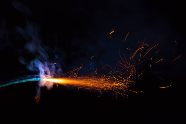 istock Burning fuse with sparks and blue smoke on black background 891367230