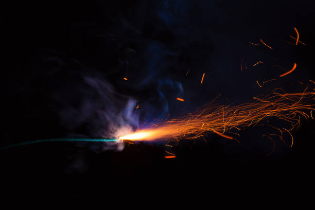 istock Burning fuse with sparks and blue smoke on black background 891367244