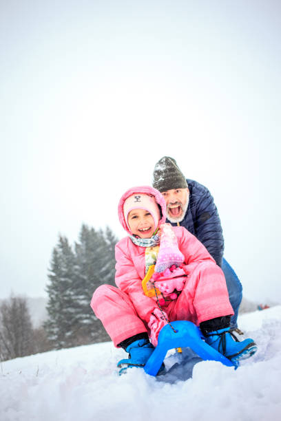 istock Father and Daughter having Fun on the Show with the Sled 891373796