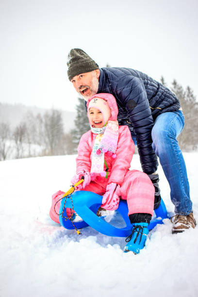istock Father and Daughter having Fun on the Show with the Sled 891373798