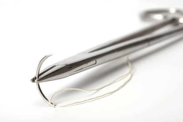 Surgical suture needle and thread holder The old holder  with a surgical needle and silk. On a white background. surgical needle stock pictures, royalty-free photos & images